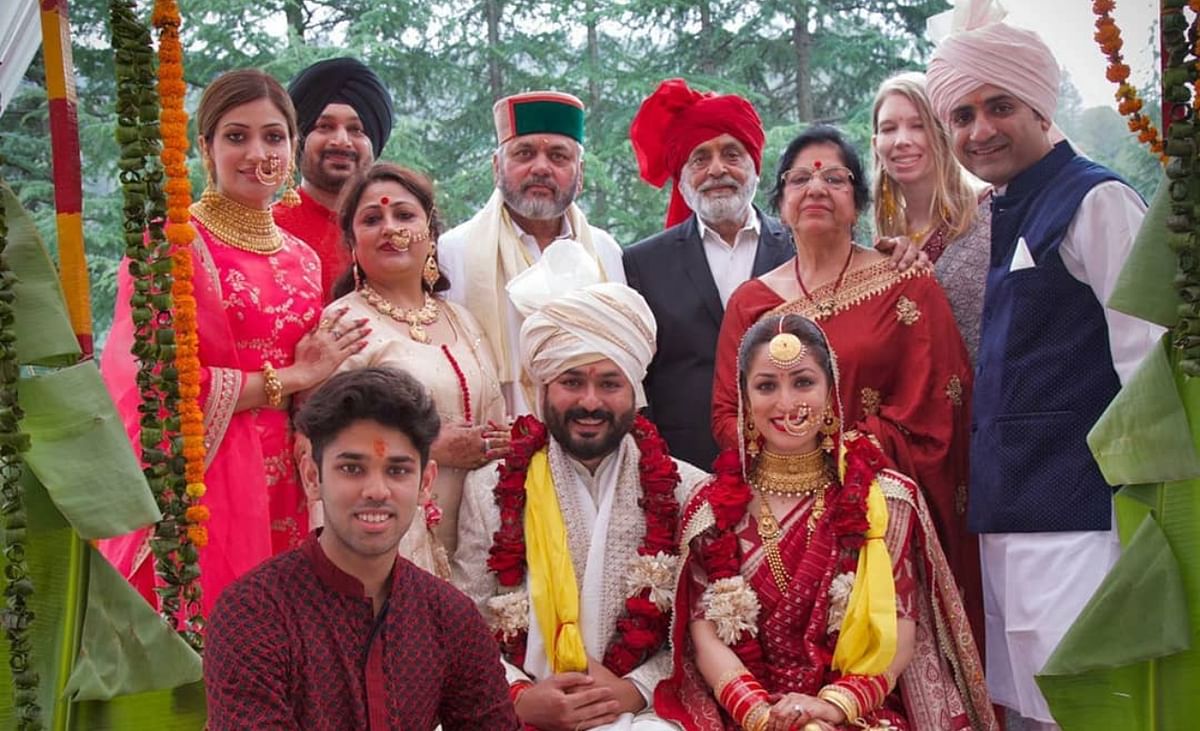 Newlyweds pose with their family members.