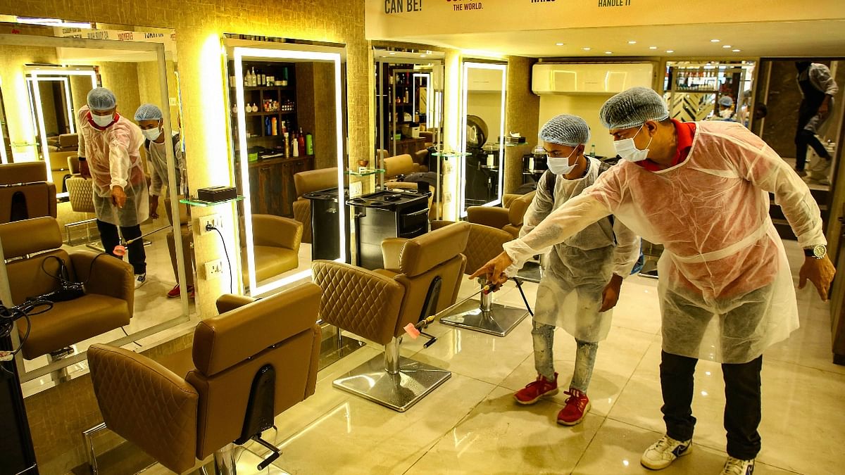 Workers sanitize a salon ahead of its reopening, in Mumbai. Credit: PTI