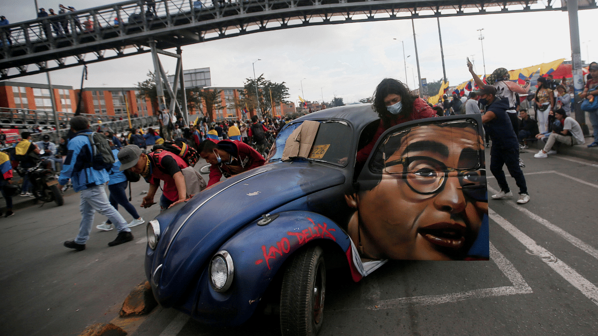 People push a car with the image of late Colombian humorist and journalist Jaime Garzon painted on it during a protest demanding government action to tackle poverty, police violence and inequalities in healthcare and education systems, in Bogota, Colombia. Credit: Reuters Photo