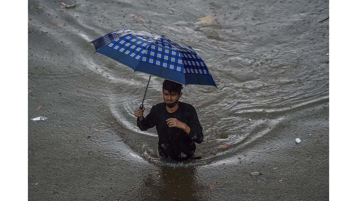 A man walks on a flooded road during heavy monsoon rains in Mumbai. Credit: AFP Photo