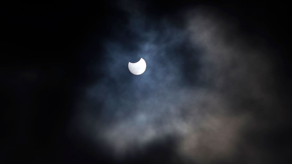 A partial solar eclipse is seen through cloud cover from Primrose Hill in central London. Credit: AFP Photo