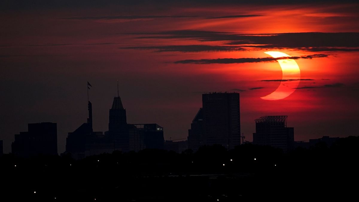 A partial solar eclipse rises over the Baltimore skyline. Credit: AP Photo