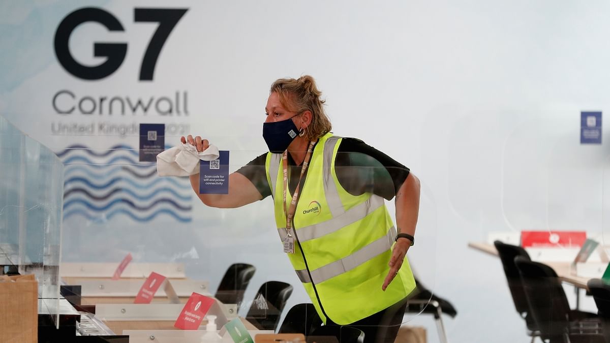 A woman cleans anti-coronavirus disease (COVID-19) screens on desks at a media centre inside the National Maritime Museum, as preparations are underway for the G7 leaders summit, Falmouth, Cornwall, Britain. Credit: Reuters Photo