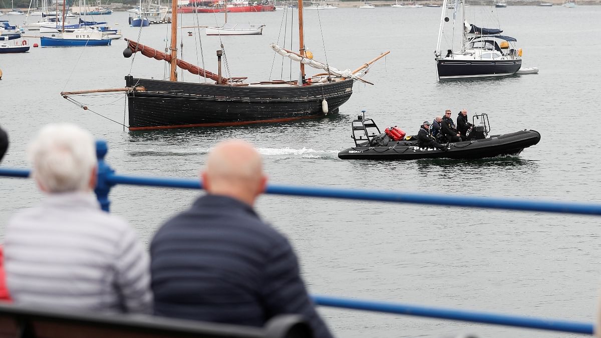People look on as security forces ride on a boat, as preparations are underway for the G7 leader's summit, Cornwall, Britain. Credit: Reuters Photo