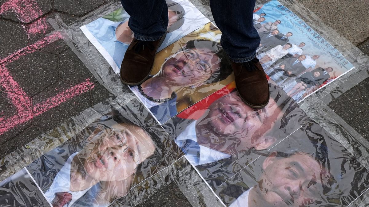 A participant steps on the photos of Chinese President Xi Jinping and Hong Kong Chief Executive Carrie Lam during a rally at Union Square to support Hong Kong in New York. Credit: AFP Photo