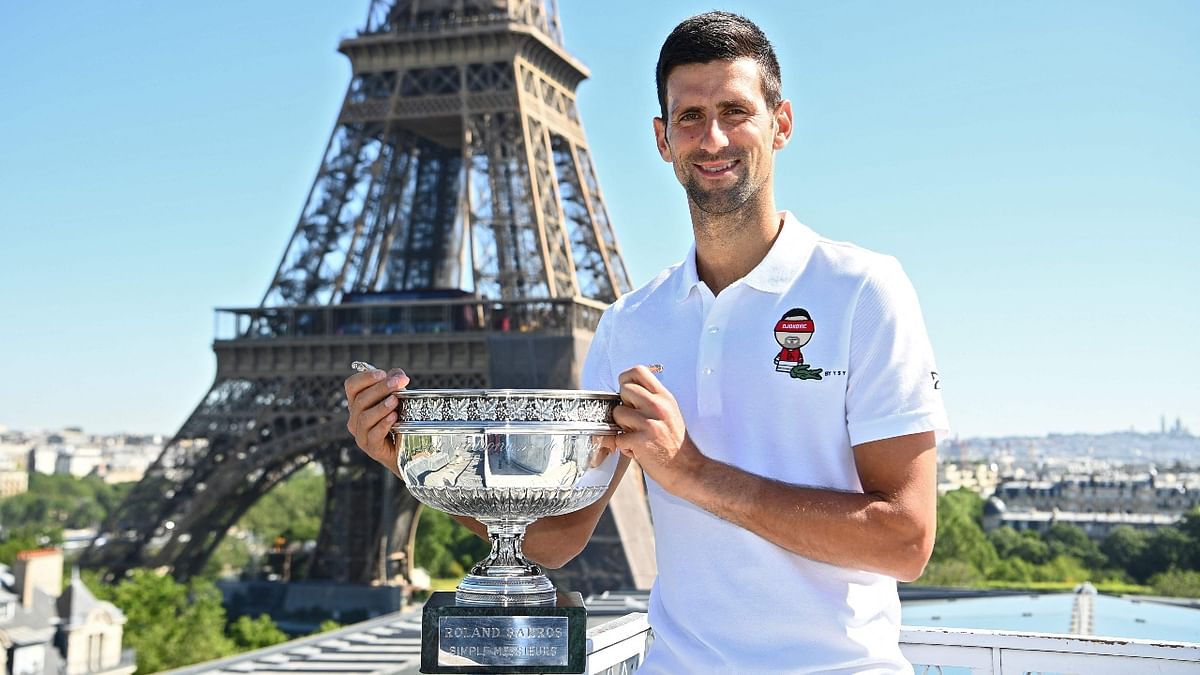 Serbia's Novak Djokovic poses with the trophy in front of the Eiffel tower in Paris, during a photocall one day after winning the Roland Garros 2021 French Open tennis tournament. Credit: AFP Photo