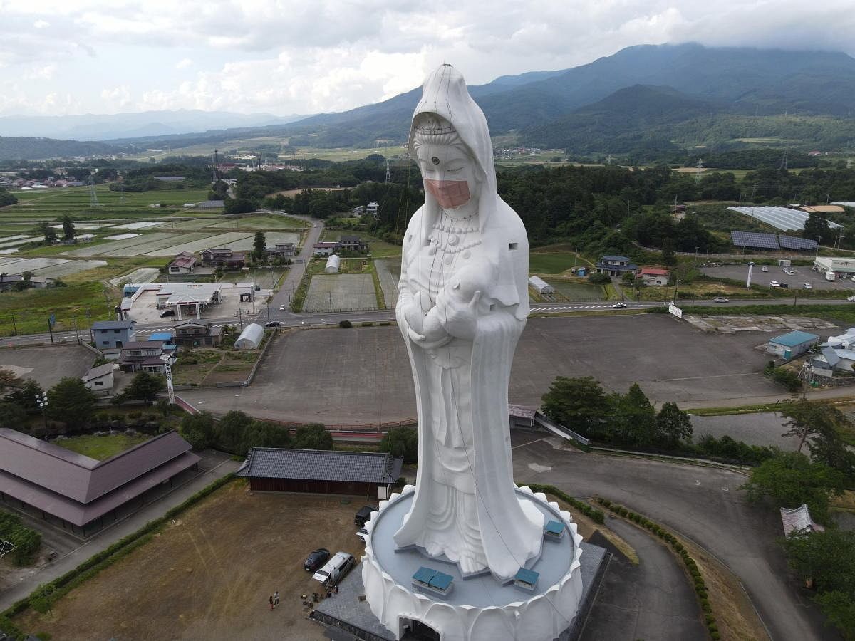 A mask on a 57 meters tall Buddhist goddess statue to pray for the end of the coronavirus disease (COVID-19) pandemic at Houkokuji Aizu Betsuin in Aizuwakamatsu. Credit: Reuters Photo