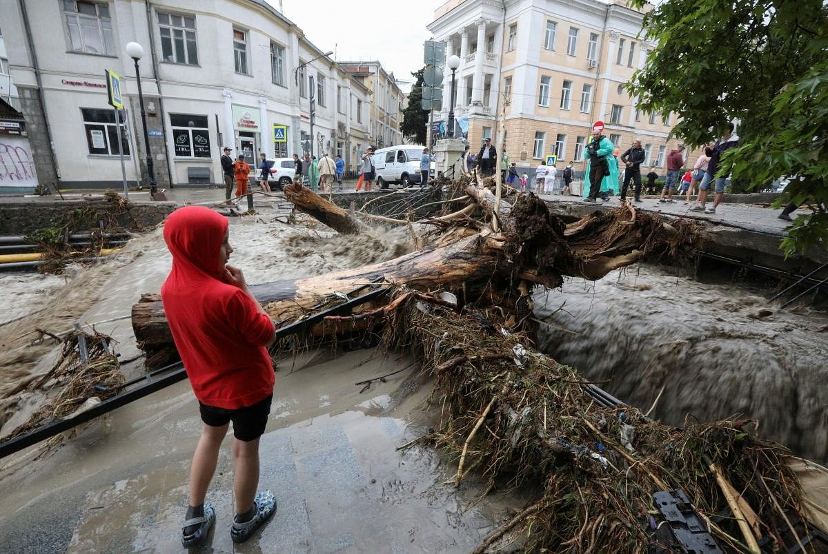 People gather in a street affected by flooding after heavy rainfall in Yalta, Crimea. Credit: Reuters Photo