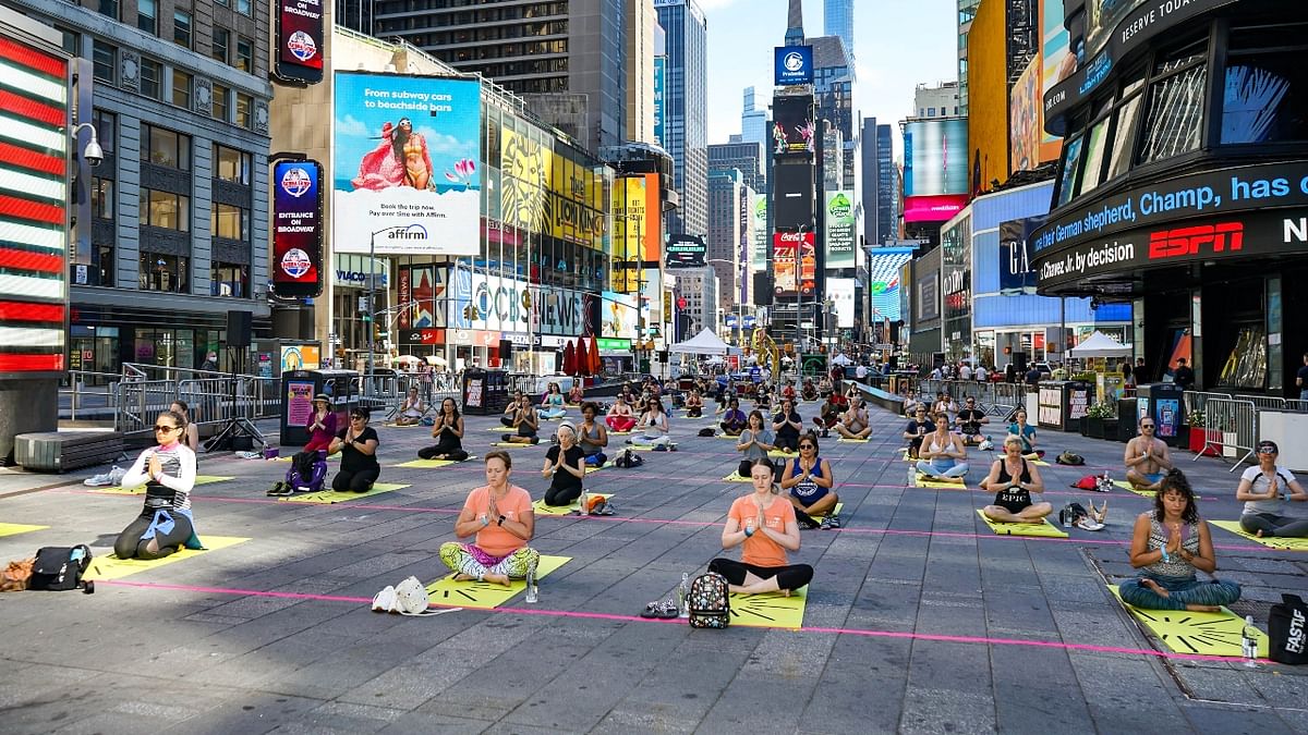 With Yoga mats spread out keeping in mind social distancing guidelines, people from various walks of life and nationalities performed Yoga asanas and exercises in the middle of Times Square, surrounded by its distinctive giant and towering LED screens. Credit: PTI Photo