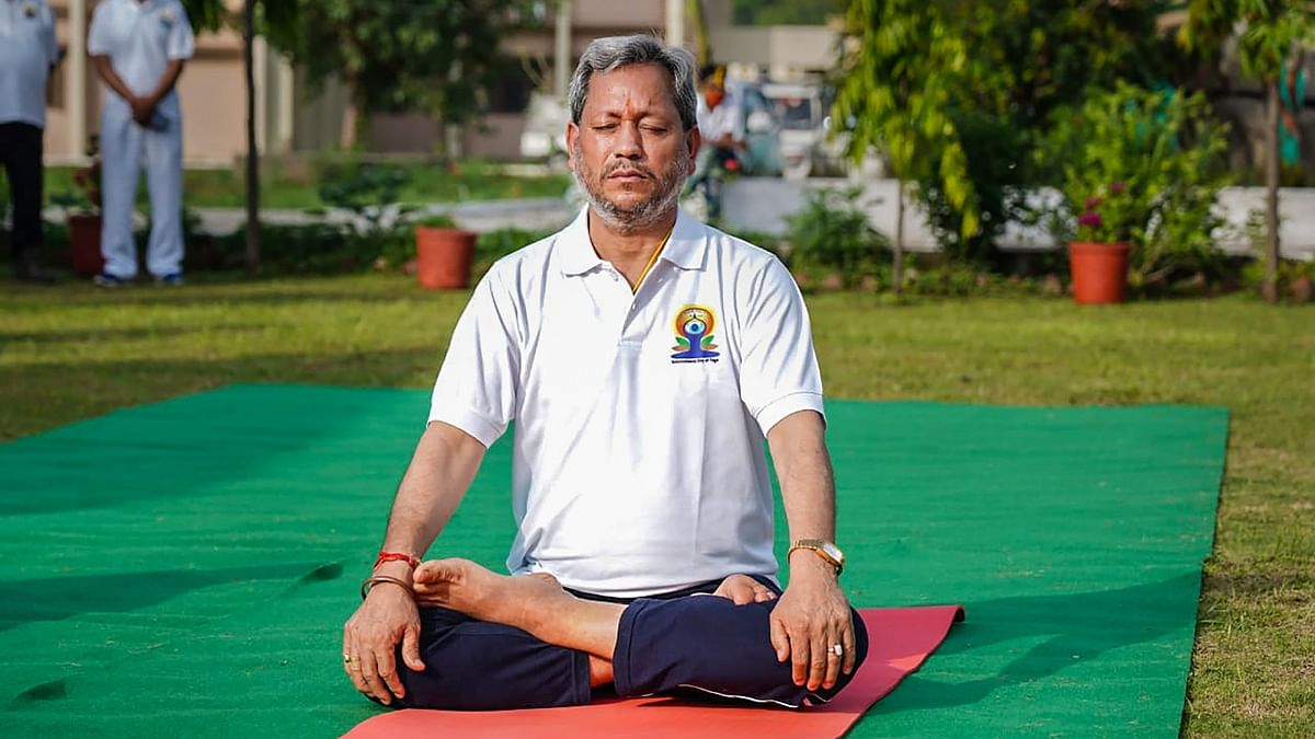 Uttarakhand Chief Minister Tirath Singh Rawat performs a Yoga asana on International Day of Yoga, in Harrawala. Credit: PTI Photo