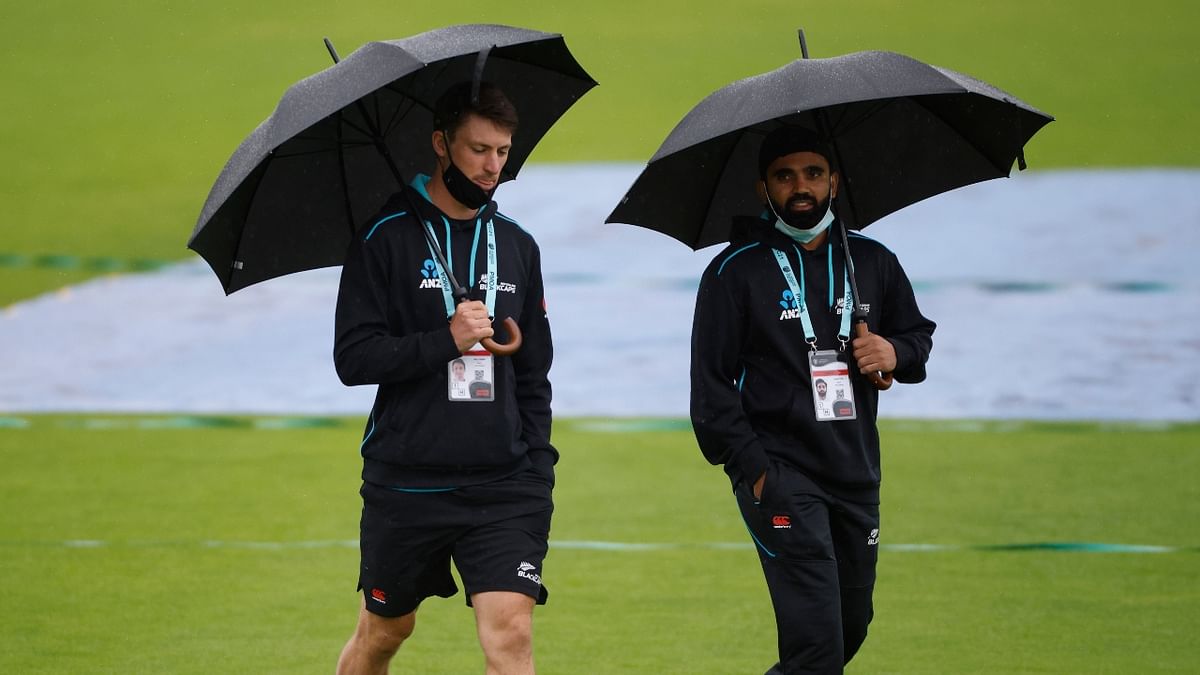 New Zealand's Will Young and Ajaz Patel walk on the field as rain stops the play. Credit: Reuters Photo