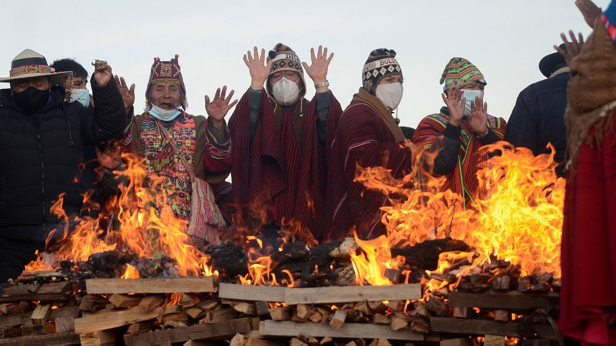 Bolivia's President Luis Arce (C) raises his hands during an ancestral ceremony to ring in the Aymara New Year, in Tiwanaku, Bolivia. Credit: Reuters photo