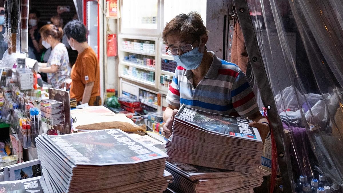 Apple Daily employees are seen busy working in the printing room as the last edition of the newspaper is printed in Hong Kong. The 26-year-old tabloid announced closure after having its assets frozen by the police. Credit: AFP Photo