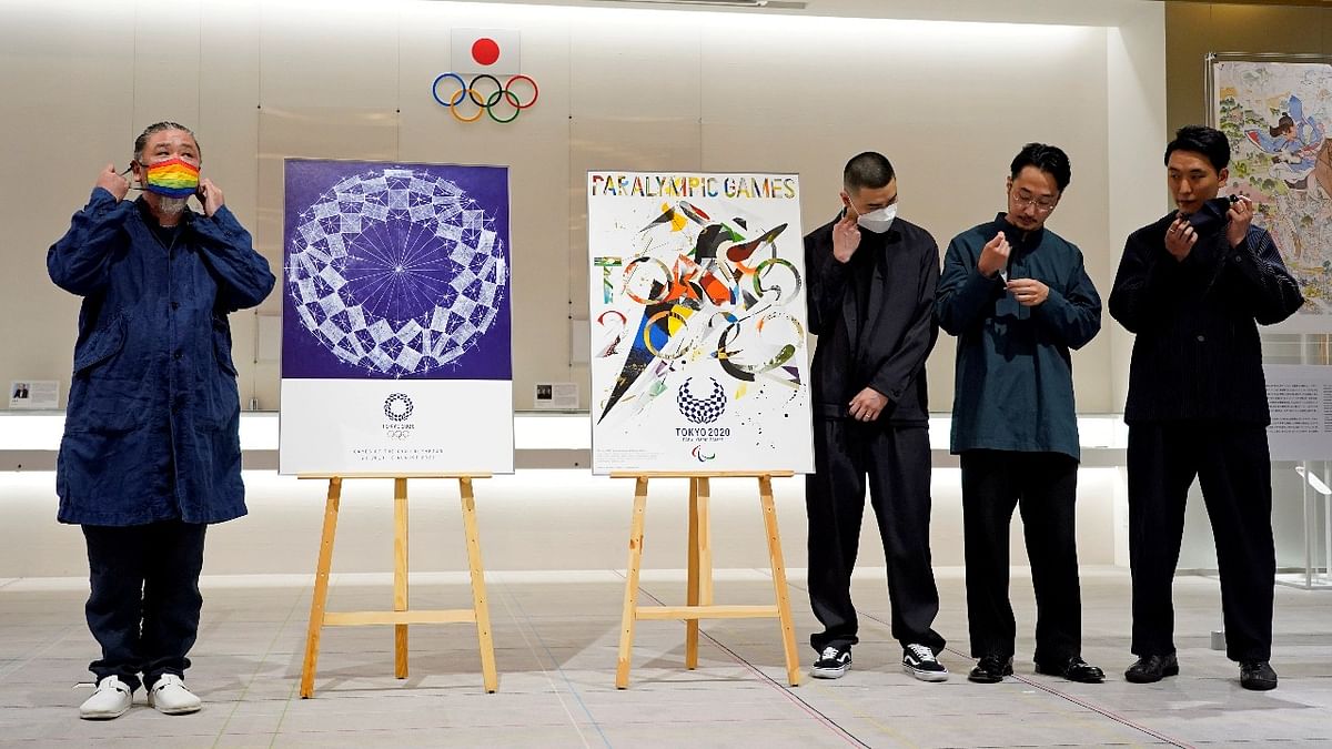 Graphic designer Asao Tokolo and graphic designers' group GOO CHOKI PAR members Q Asaba, Kent Iitaka and Rei Ishii take off their protective masks before a photo session next to their posters that will be used to promote Tokyo 2020 Olympic and Paralympic Games during a presentation event in Tokyo. Credit: Reuters photo