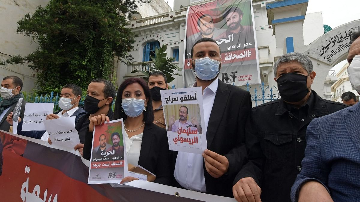 In this file photo taken on May 3, 2021 members of the Tunisian Journalists Union pose with posters in support of imprisoned Moroccan journalists Omar Radi and Souleimane Raissouni (bottom R), on the occasion of World Press Freedom Day in Tunis. Credit: AFP Photo