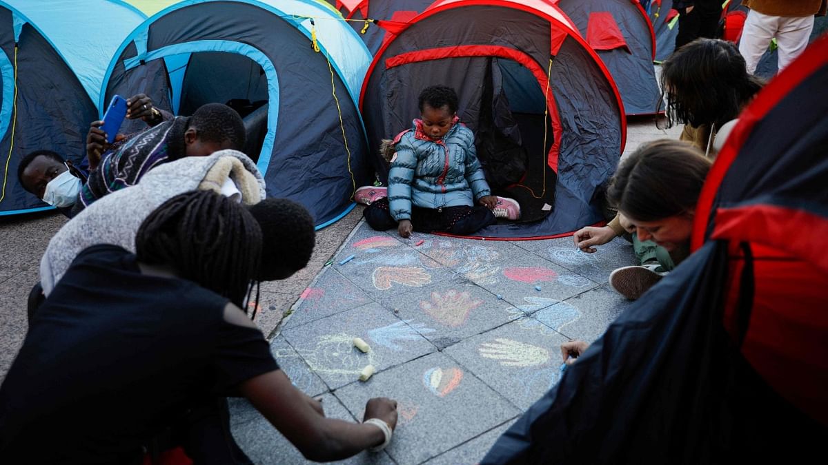 Homeless migrants and their supporters draw hands on the floor after installing tents during an action organised by French association Utopia56 in front of the City Hall in Paris, on June 24, 2021, to highlight the plight of the homeless in central Paris. Credit: AFP Photo