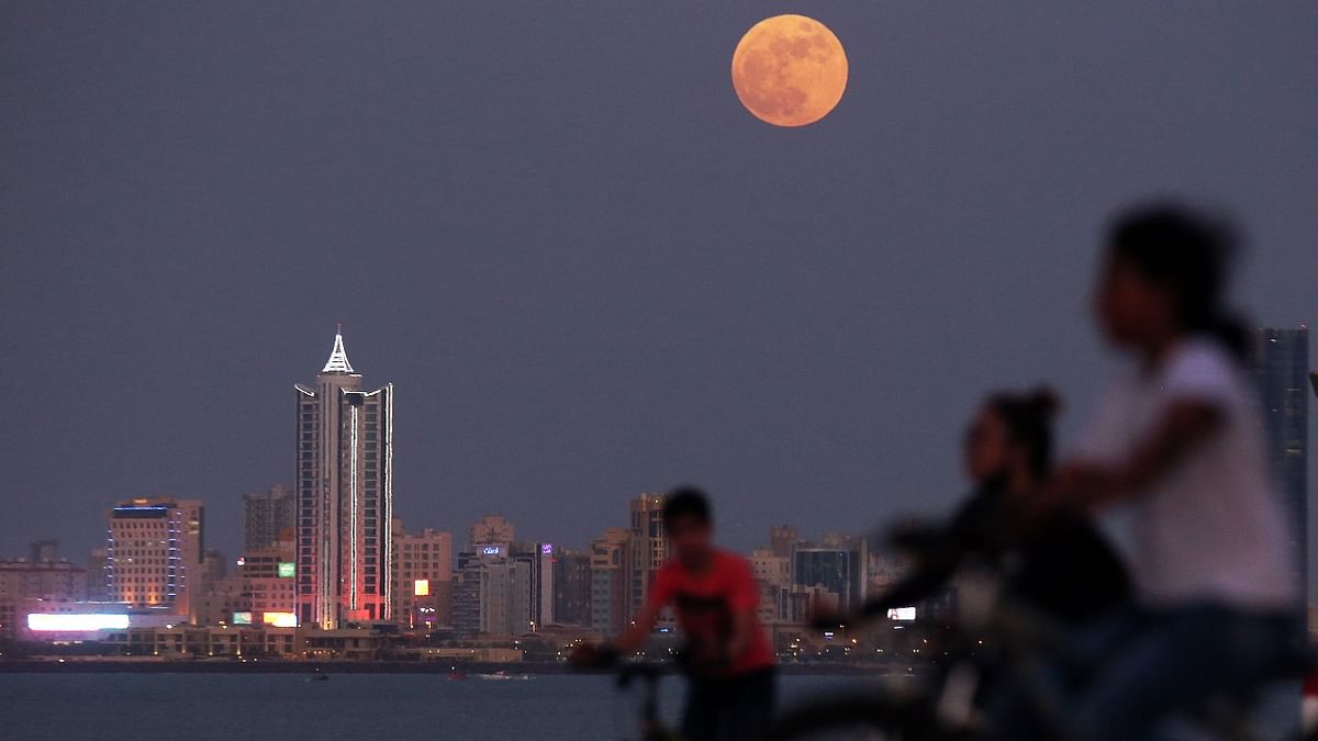 Children watch as the Strawberry Moon ]rises in Kuwait City. Credit: AFP Photo