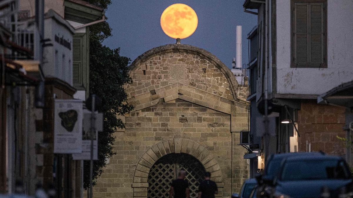 People walk beneath the rising Strawberry Moon towards the Venetian-built Famagusta gate in the old-walled city of Cyprus' capital Nicosia. Credit: AFP Photo