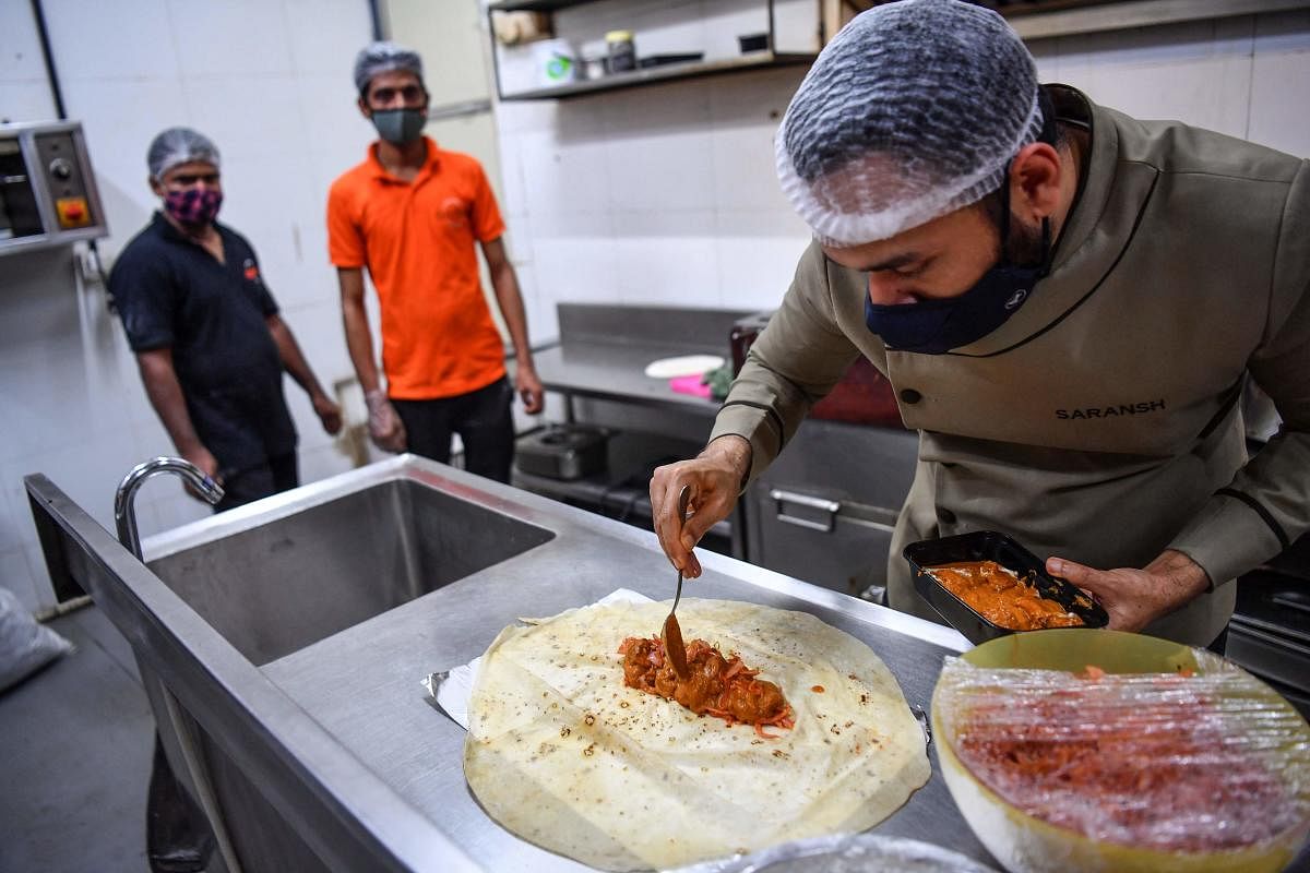 Staff watch as chef Saransh Goila (R) prepares an order in the kitchen of the Goila Butter Chicken restaurant in Mumbai. Credit: AFP Photo