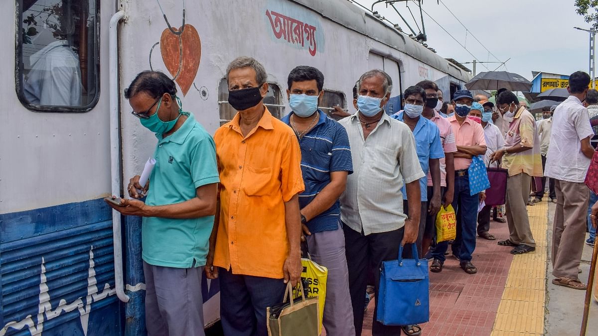 People stand in a queue at Ranaghat Railway Station to receive Covid vaccine from 'Aarogya', a mobile vaccination initiative launched by Eastern Railways' Sealdah Division, in Nadia. Credit: PTI Photo
