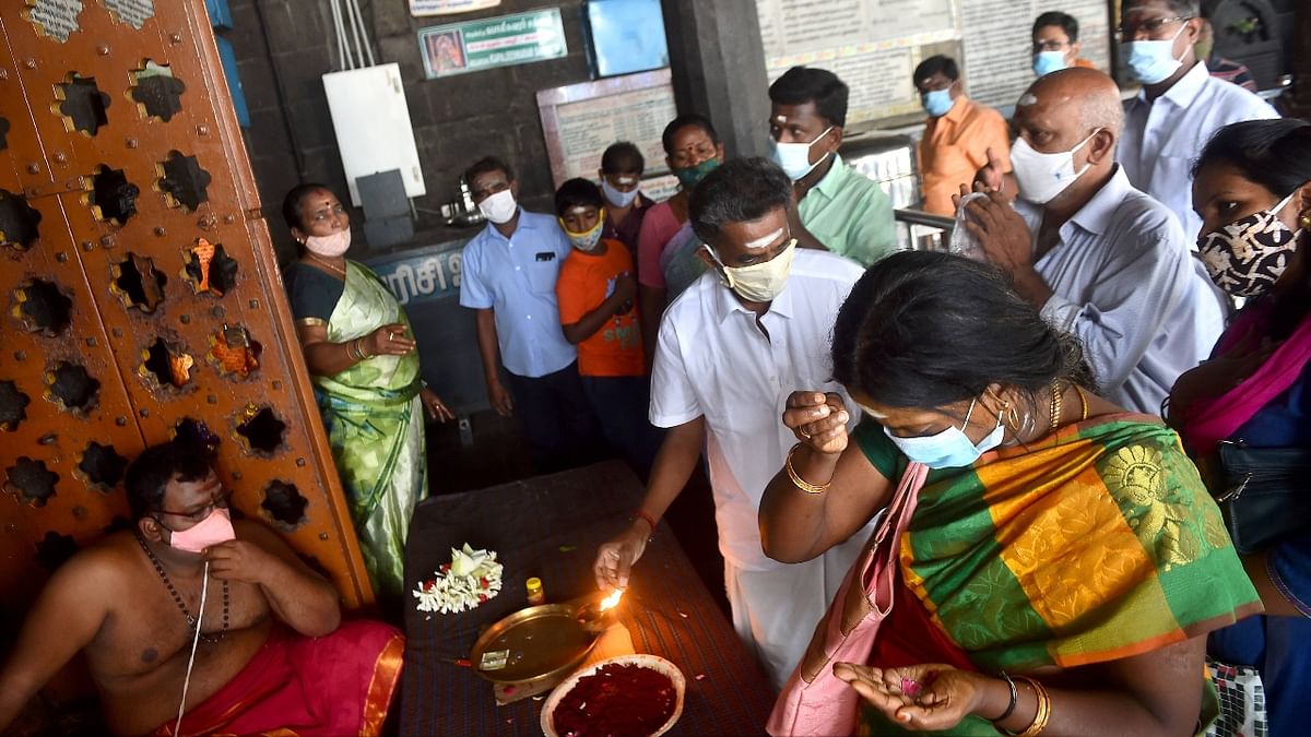Adhering to Covid-19 protocols devotees are seen offering prayers at Kapaleeshwar temple in Chennai. Credit: PTI Photo