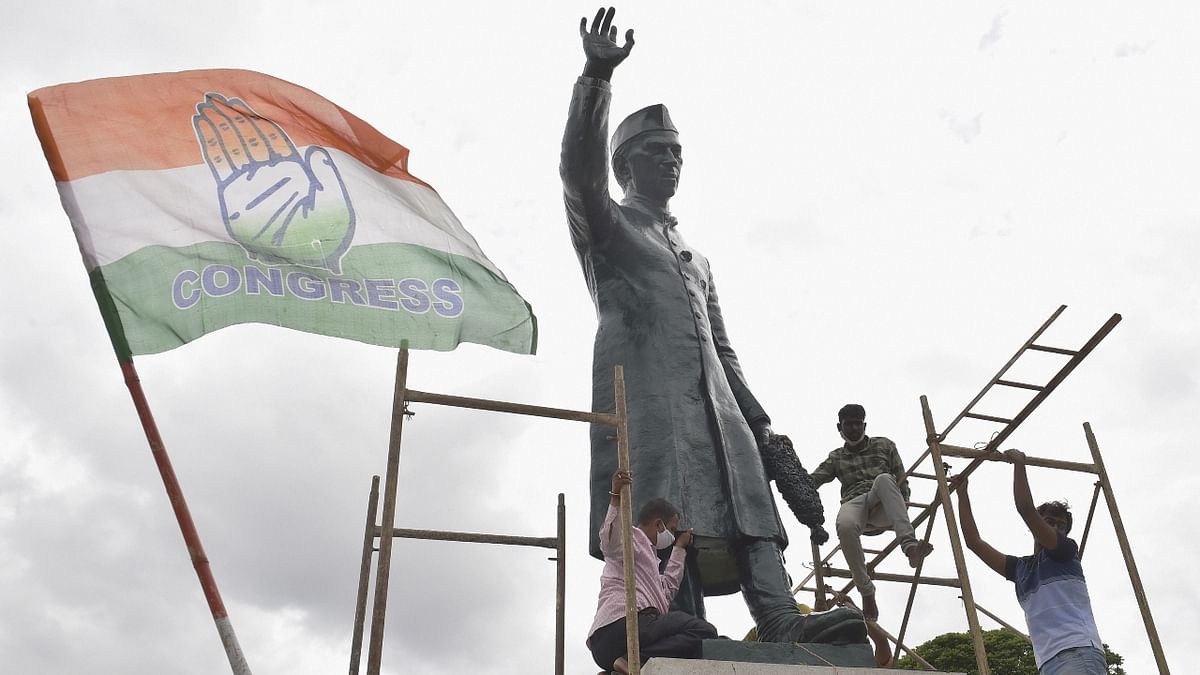 Congress party workers celebrate with party flags after the statue of former Prime Minister Jawahar Lal Nehru re-installed on its pedestal, in the premises of the Vidhana Soudha, in Bengaluru.