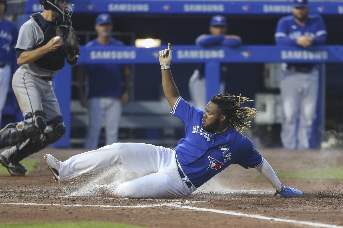 Vladimir Guerrero Jr. #27 of the Toronto Blue Jays slides across the plate as he scores on a sacrifice fly by Cavan Biggio during the fifth inning against the Seattle Mariners at Sahlen Field. Credit: AFP Photo
