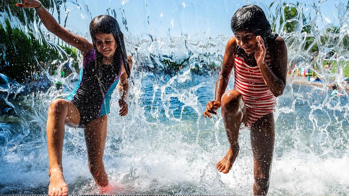 Children cool down as they play in water at an amusement park in US.