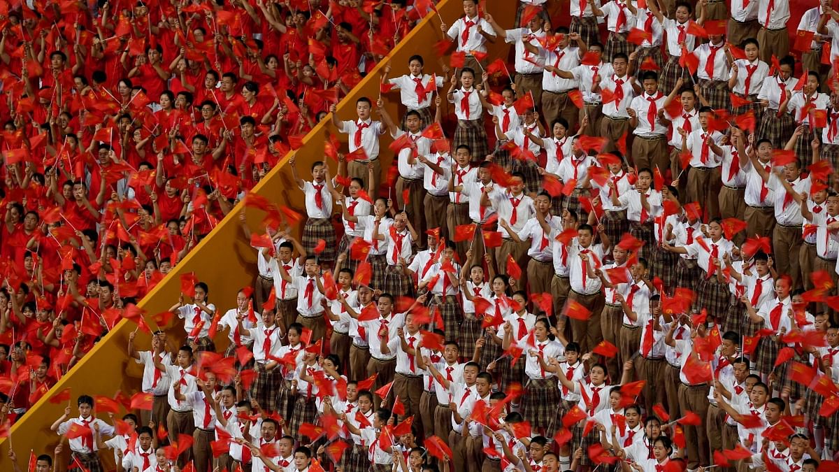 In the capital's immense Tiananmen Square, tens of thousands of handpicked spectators cheered, sang, and waved flags. Credit: AFP Photo