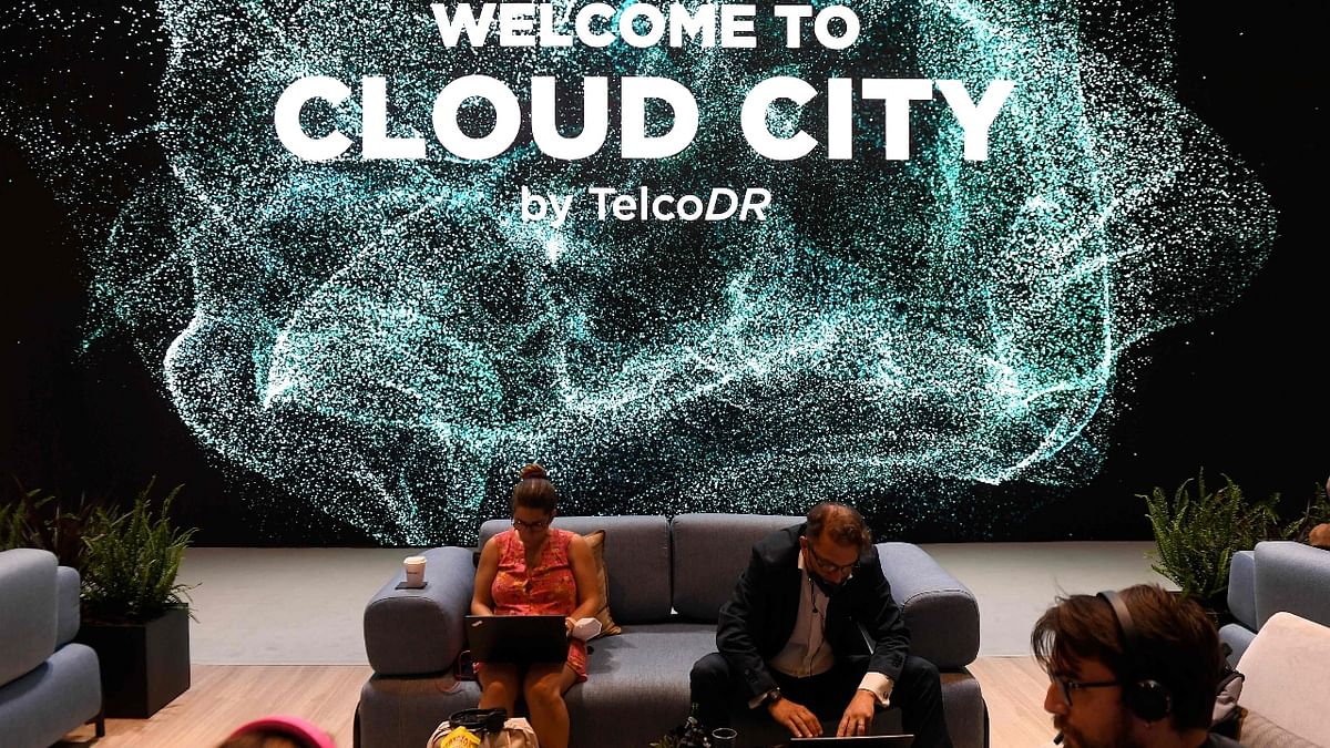 Visitors sit at the TelcoDR stand during the Mobile World Congress (MWC) fair in Barcelona. Credit: AFP Photo