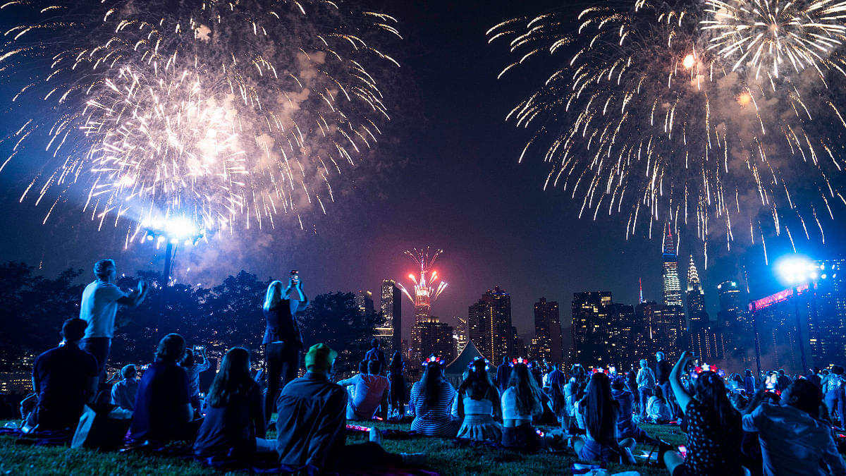 Spectators watch from the Queens borough of New York as fireworks are launched over the East River and the Empire State Building during the Macy's 4th of July Fireworks show. Credit: AP Photo