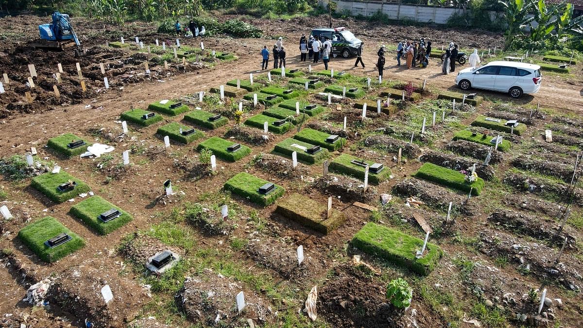 A morbid grid of graves widens as excavators dig deep, piling up soil to make space for Indonesia's pandemic dead to be laid to rest. Credit: AFP Photo