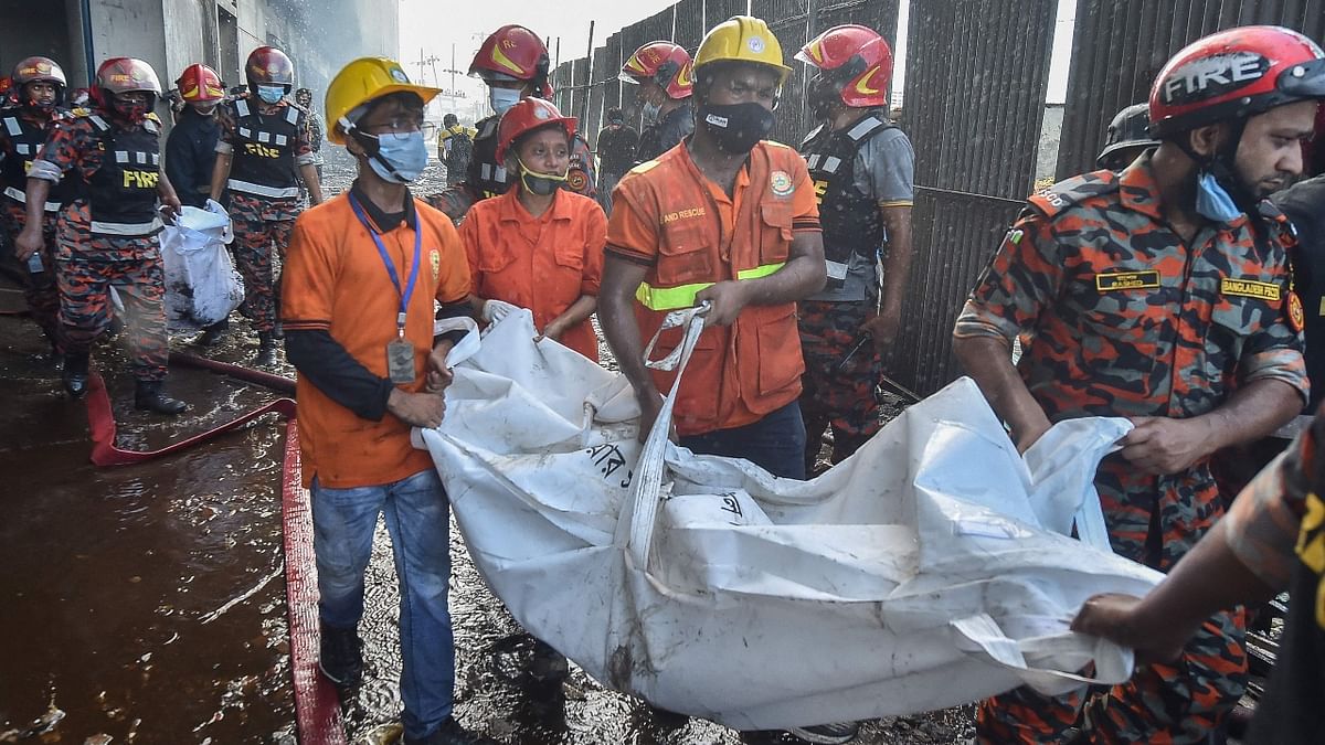 Firefighters and rescue workers recover bodies of victims who died in the fire that broke out a day before in a beverage and food factory in Rupganj, Bangladesh. Credit: AFP Photo