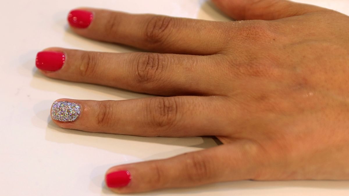 A customer gets a microchip installed to one of her nails at Lanour Beauty Lounge in Dubai.