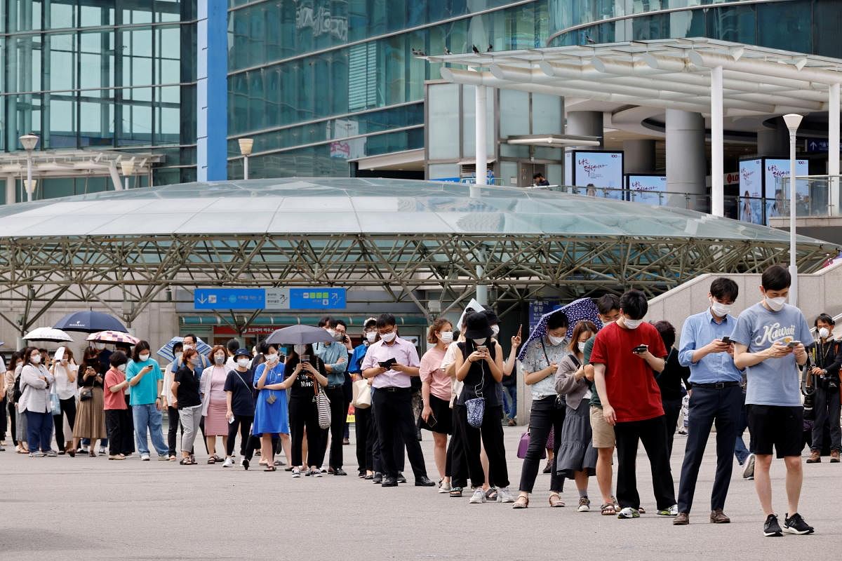 People wait in line for a Covid-19 test at a testing site, temporarily set up at a railway station in Seoul, South Korea. Credit: Reuters Photo