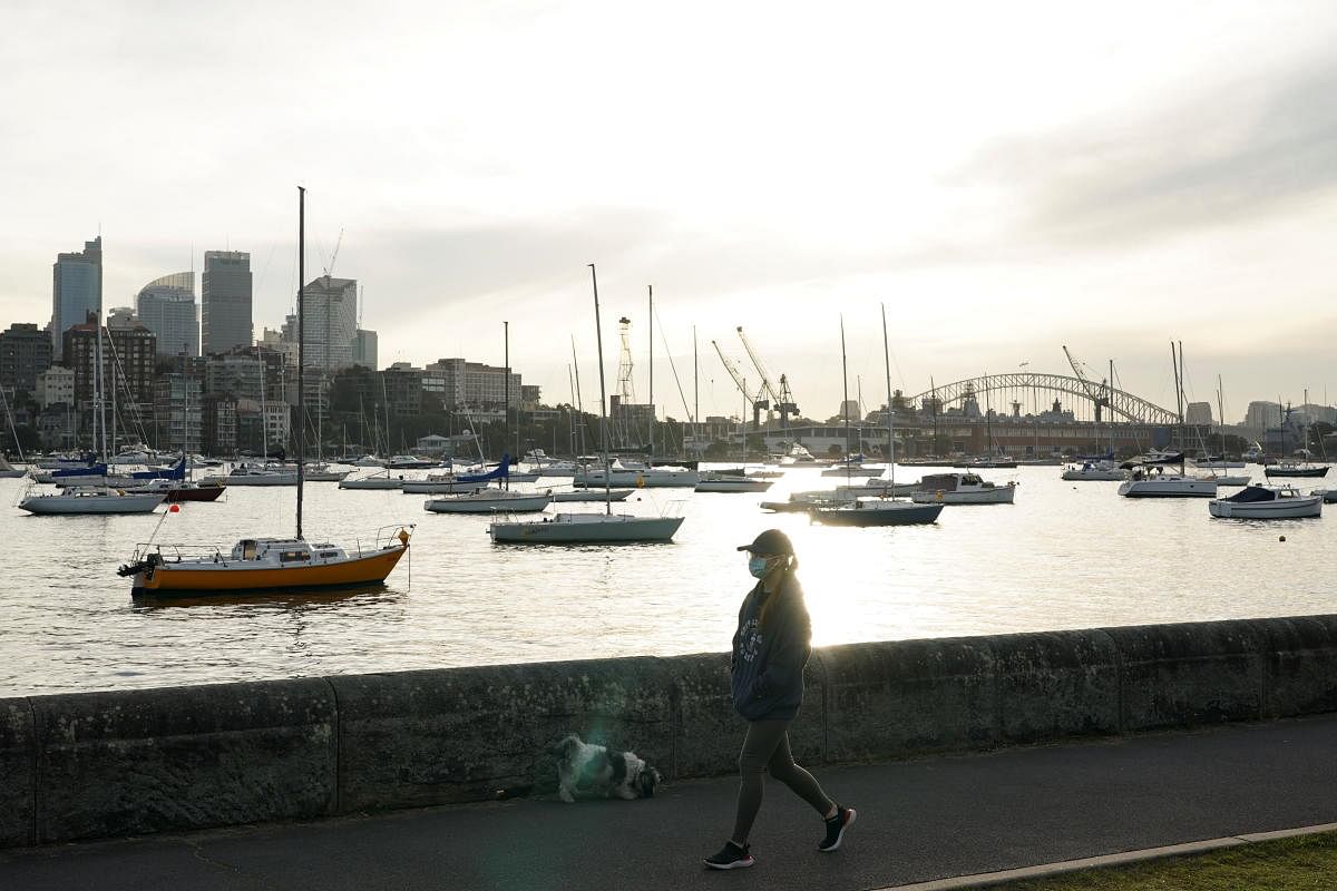 A woman wearing a protective face mask walks along a waterfront path during a lockdown to curb the spread of a coronavirus disease outbreak in Sydney, Australia. Credit: Reuters Photo