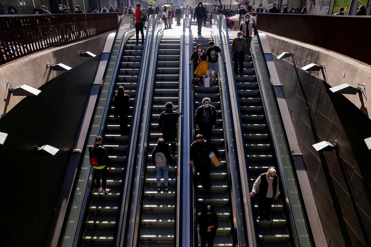 People are seen on a subway escalator in Santiago, on July 8, 2021. - Chilean President Sebastian Pinera announced on Thursday, July 8, modifications to the Step by Step plan, which would come into effect on Thursday, July 15. The changes seek