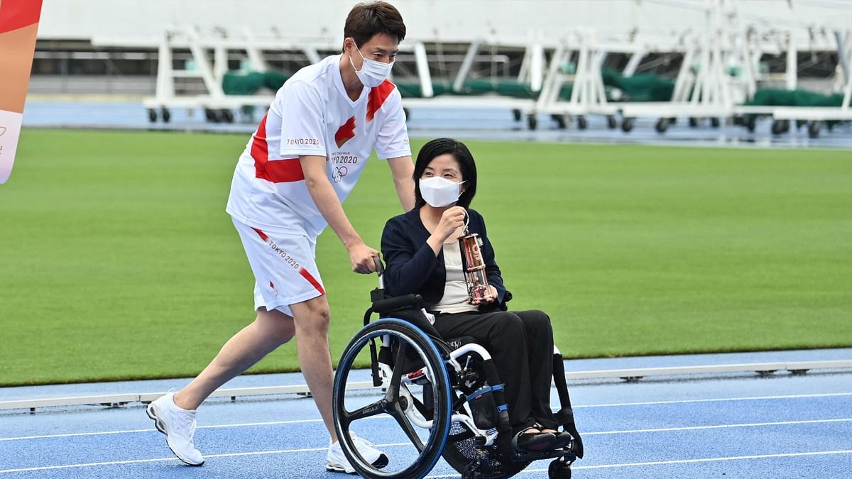 Former Japanese professional tennis player Shuzo Matsuoka and former Japanese Paralympian Aki Taguchi arrive to attend the unveiling ceremony of the Olympic flame at the Komazawa Olympic Park General Sports Ground on the first day of the torch relay in Tokyo. Credit: AFP Photo