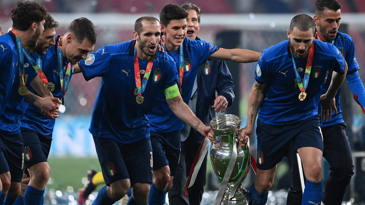 Chiellini (C-L) and defender Leonardo Bonucci (C-R) pose with the European Championship trophy. Credit: AFP Photo