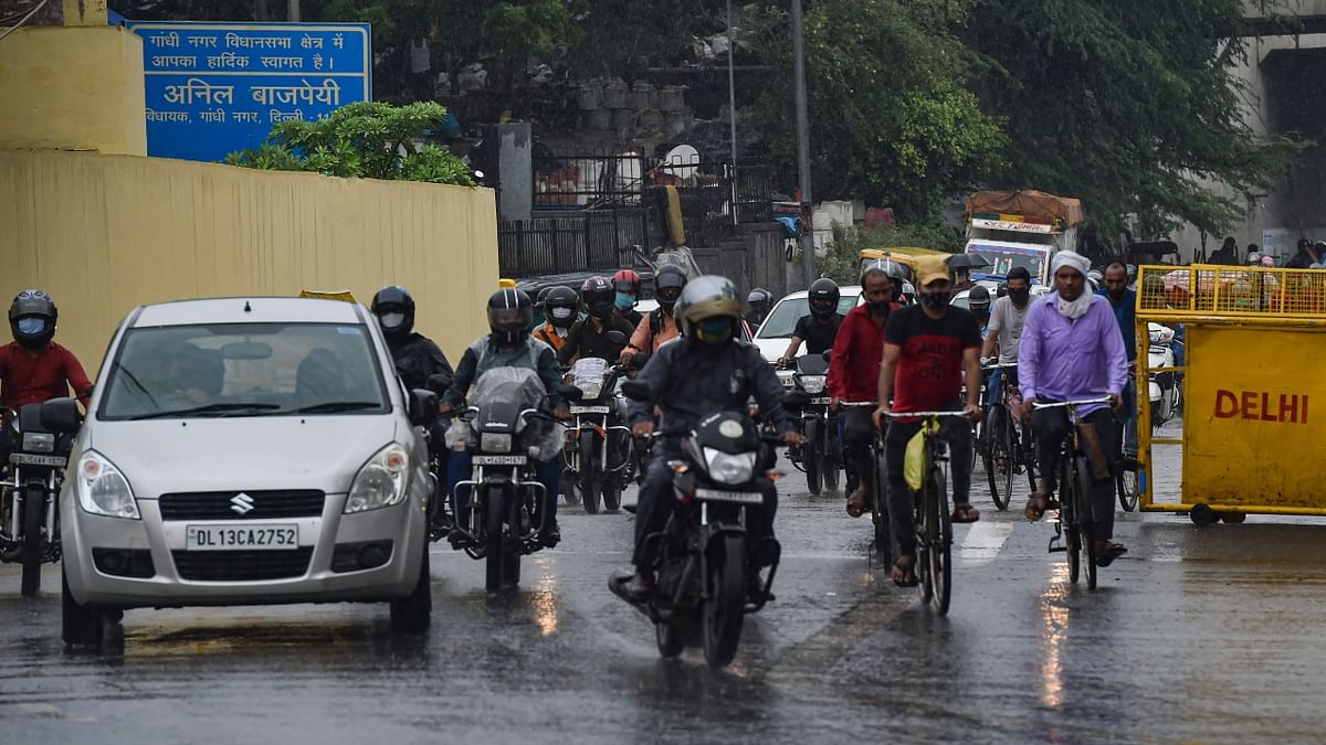 Vehicles ply on a road during rain as monsoon reaches New Delhi. Credit: PTI Photo
