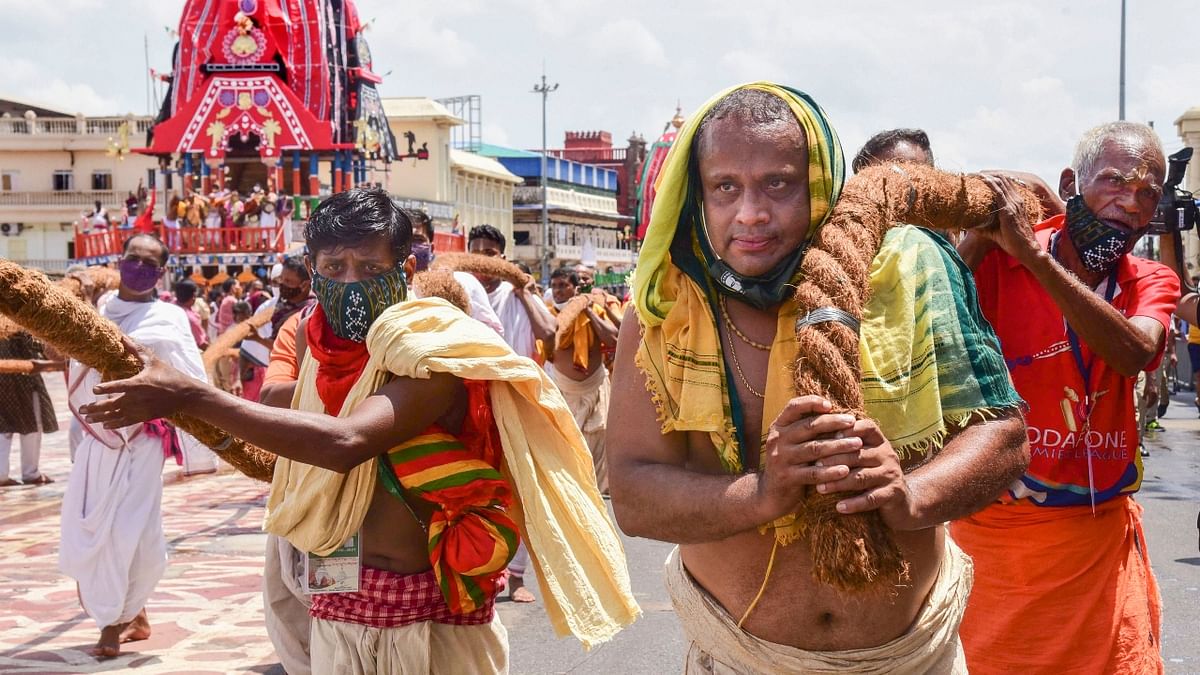 Priests pull chariots from their construction site to the Jagannath temple on the eve of Rath Yatra festival, in Puri.