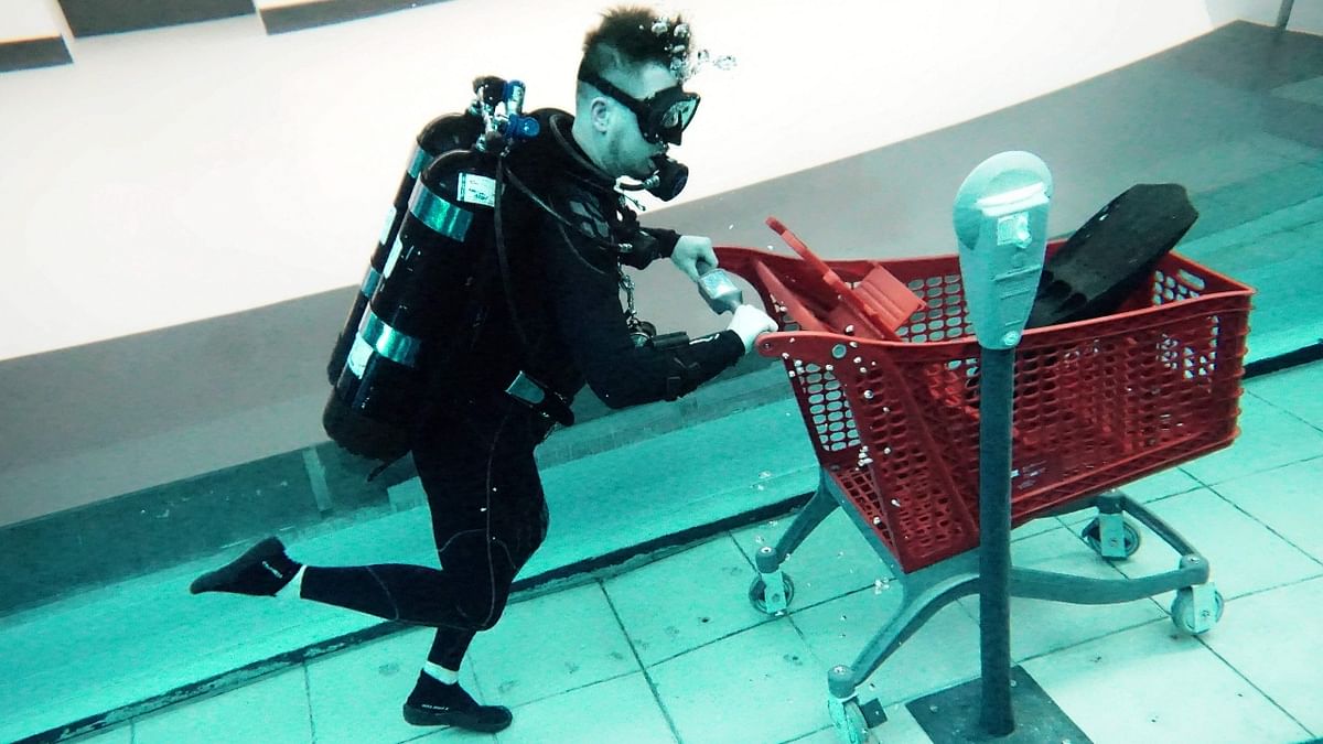 A diver is seen with a shopping cart at the Deep Dive Dubai. Credit: AFP Photo