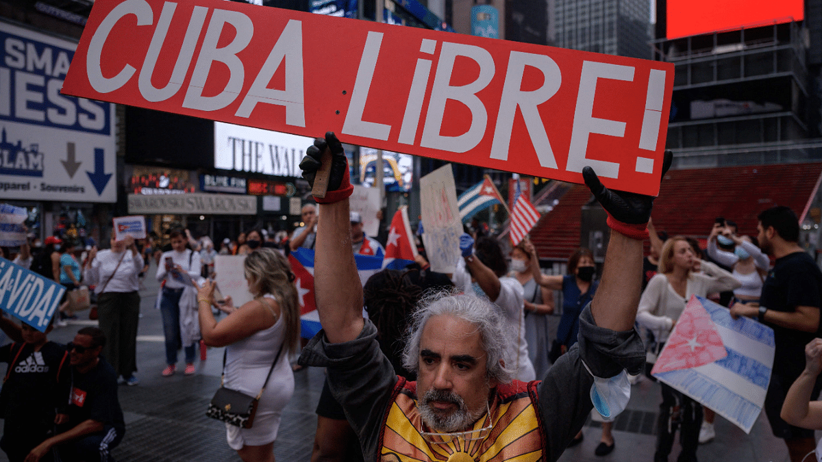 Demonstrators hold placards during a rally held in solidarity with anti-government protests in Cuba, in Times Square, New York. Credit: AFP Photo