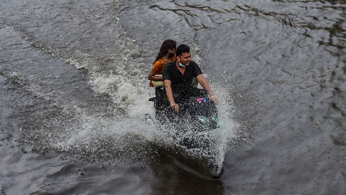 A man rides a motorcycle on a waterlogged road after heavy rains in New Delhi.