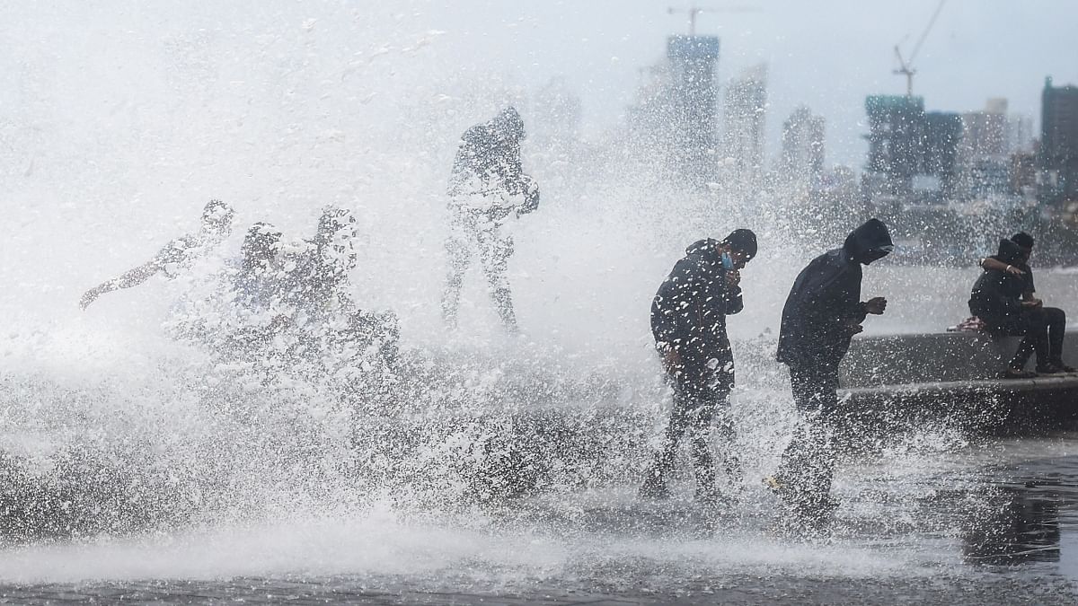 People get drenched in waves during monsoon rains at the Worli sea face in Mumbai. Credit: PTI Photo
