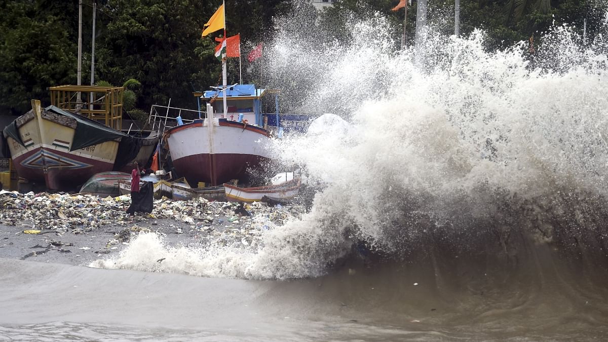 Waves lash boats and slums close to the shores during high tide at Badhwar park in Mumbai. Credit: PTI Photo