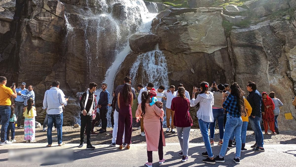 Tourists visit the waterfall at Koksar near the Atal Tunnel in Lahaul-Spiti. Credit: PTI Photo