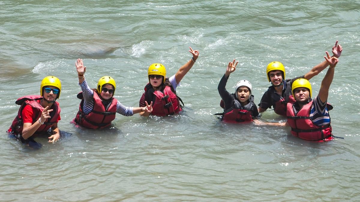 Tourists pose for a photo while enjoying a water sport in Beas river in Manali. Credit: PTI Photo