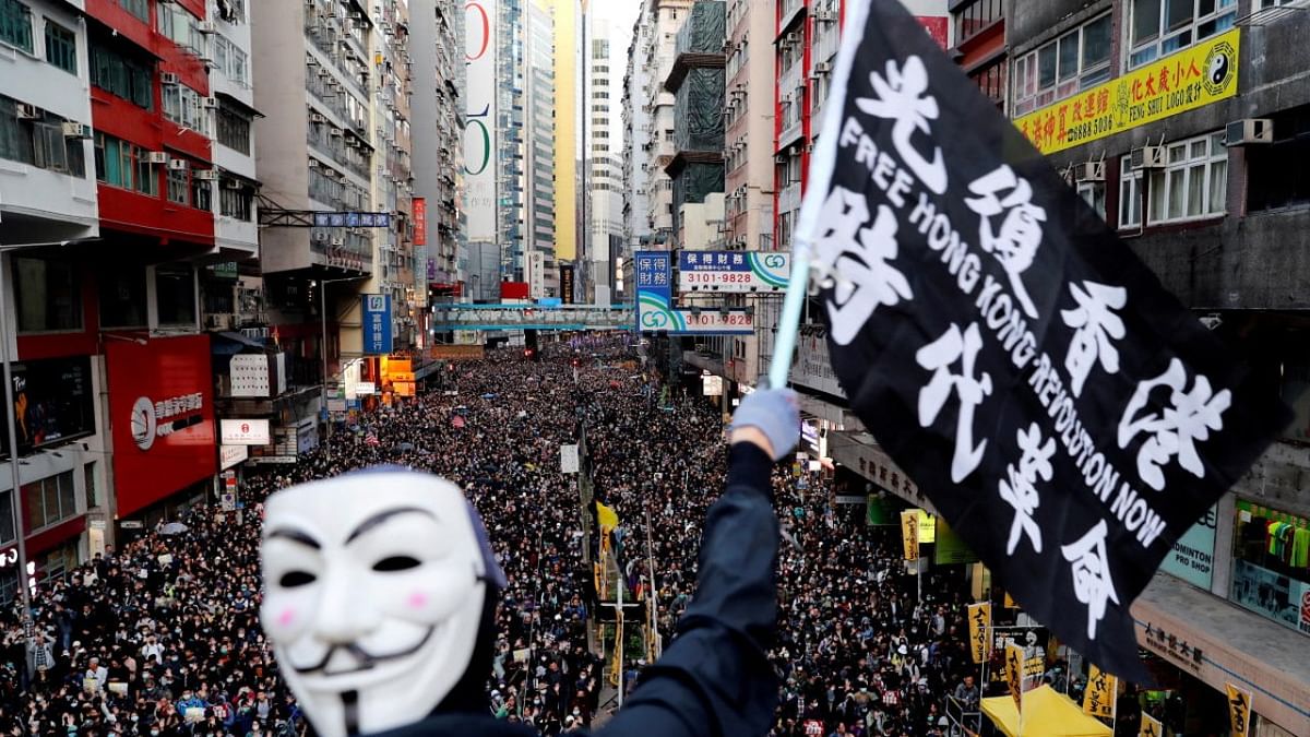 A protester wearing a Guy Fawkes mask waves a flag during a Human Rights Day march, organised by the Civil Human Right Front, in Hong Kong. (Credit: Reuters Photos/Danish Siddiqui)