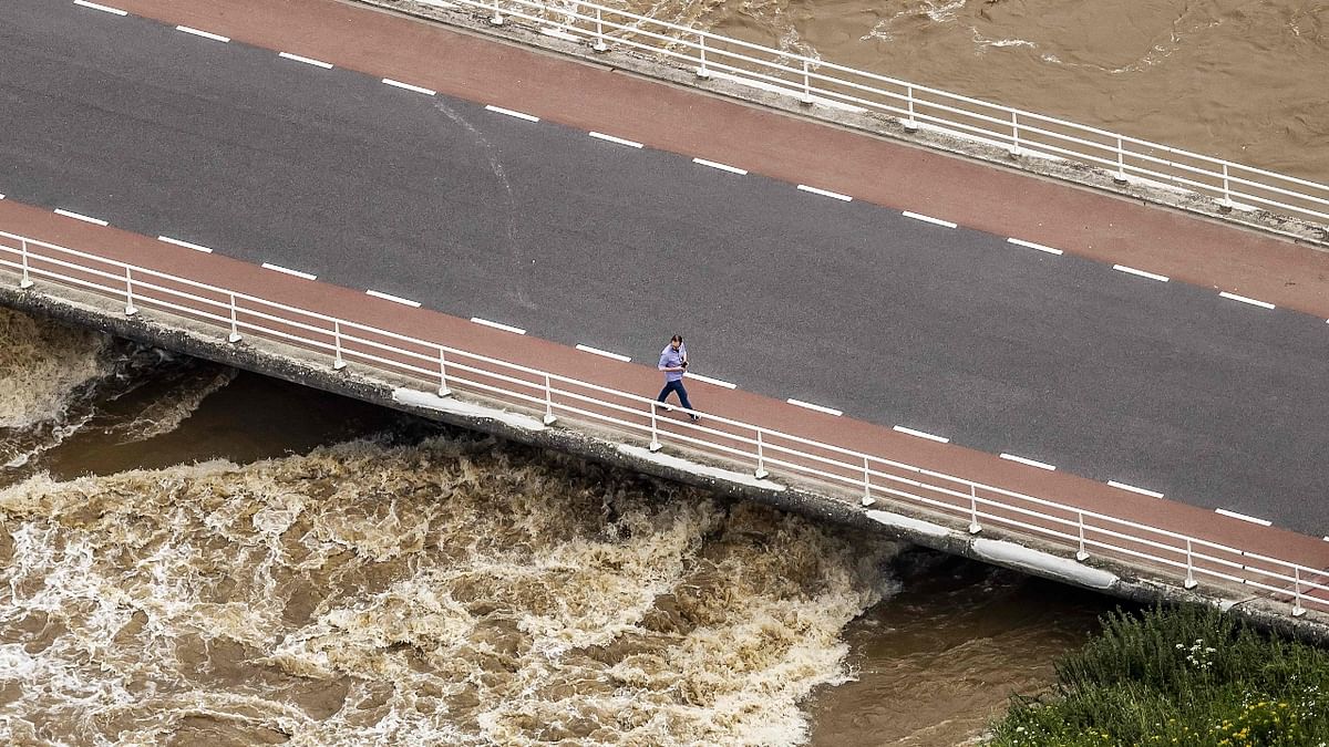 An aerial photo shows a man walking on the bridge over the Meuse. Credit: AFP Photo